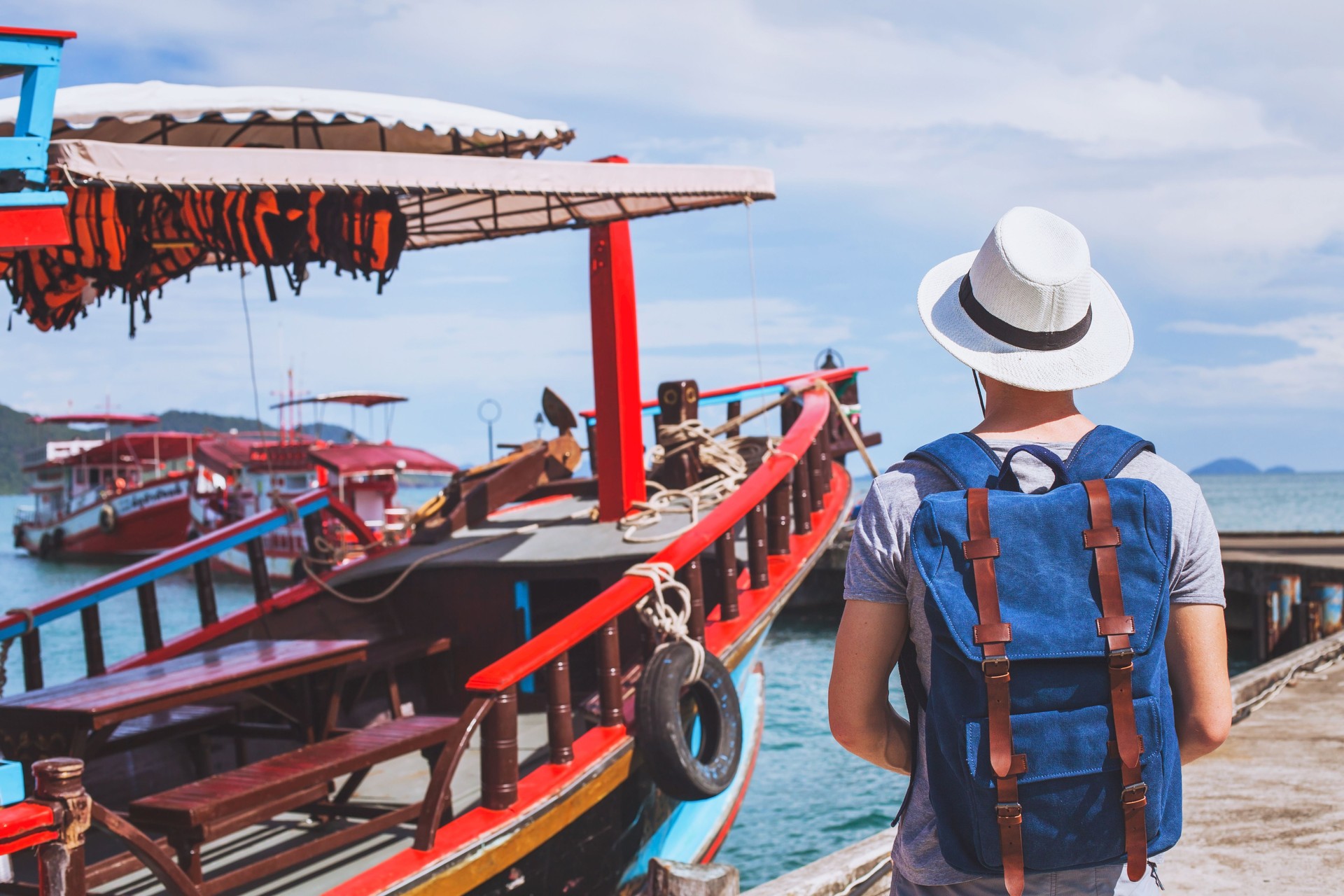 Travel to Asia, tourist near wooden boat.